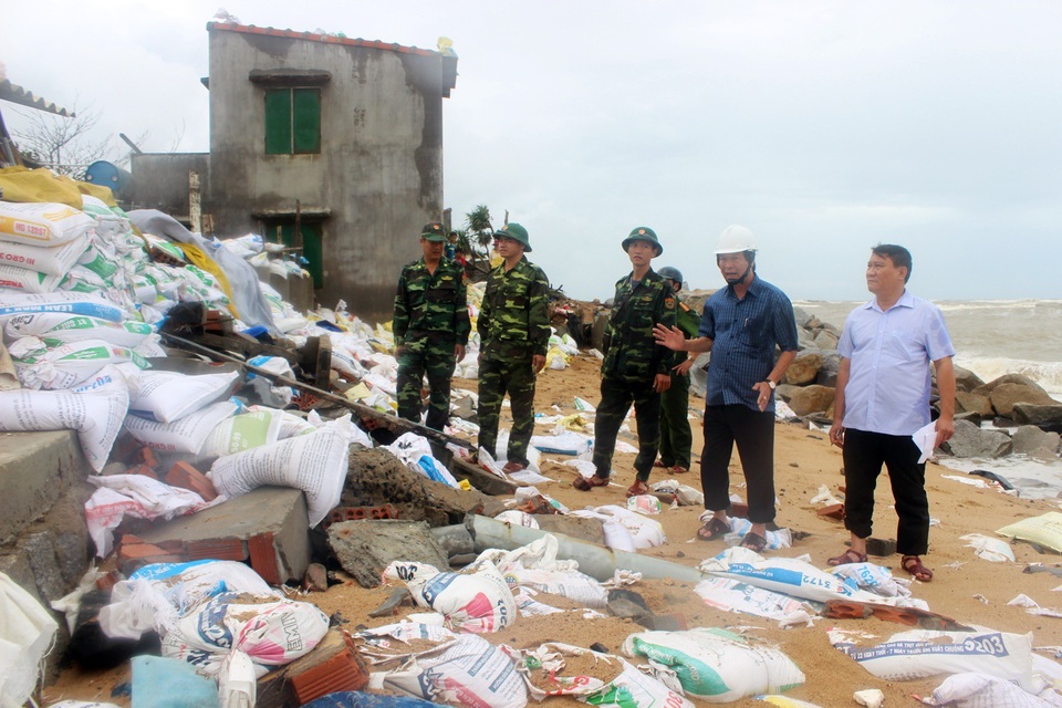 Sóng cao hơn mái nhà, hàng chục hộ dân ôm tài sản chạy bão - 4 Ông Kha (đội mũ trắng) chỉ đạo phải gấp rút di dời người và tài sản đi trong đầu giờ chiều nay