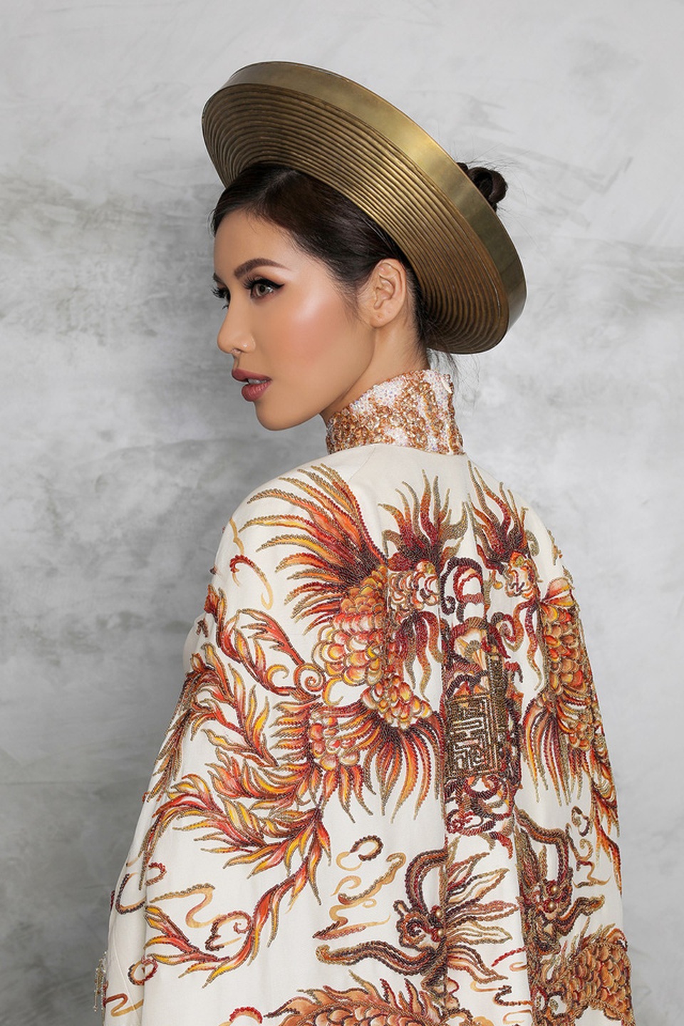 Ấn tượng hơn nữa là chiếc “Hoàng bào” cổ truyền khoác ngoài được thể hiện bằng nghệ thuật vẽ sơn mài – nghệ thuật truyền thống của thủ công mỹ nghệ và niềm tự hào của mỹ thuật Việt Nam.