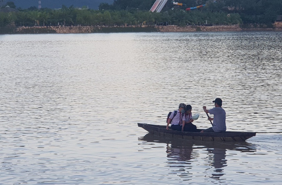 Cầu bị tháo dỡ do mưa lũ, hàng chục học sinh đi học bằng đò - 2
Một phụ huynh ở bắc sông Cái Nha Trang cũng chèo con thuyền nhỏ đón hai con đi học về, chiều 27/11/2018.