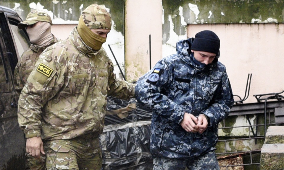 Nguy cơ Ukraine “lép vế” khi đối đầu với Nga trên biển - 1
Sĩ quan tình báo Nga áp giải một thủy thủ Ukraine bị Nga bắt giữ tới tòa án ở Crimea hôm 27/11 (Ảnh: AP)