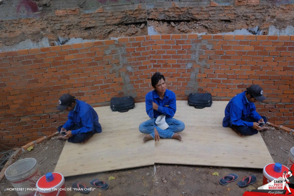 Thí sinh Phùng Trọng Tín từng có nhiều kinh nghiệm tham gia các cuộc thi sáng tác ảnh nhanh của Canon Marathon. Bức ảnh được anh Tín chụp trong con hẻm đường Nguyễn Thị Minh Khai, quận 1 đã giành giải nhì chủ đề Phản chiếu. Chia sẻ về ý tưởng và nội dung bức ảnh, anh Tín cho biết:Tôi đi lang thang trong con hẻm đường Nguyễn Thị Minh Khai thì bắt gặp 2 nhân vật là công nhân trong giờ nghỉ trưa. Để có bức ảnh phản chiếu, tôi phải mượn tấm gương lớn của người dân để tạo nên hình ảnh này.