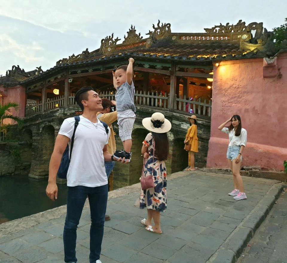 Con trai Quốc Cơ thích thú khi được đứng trên bàn tay bố.