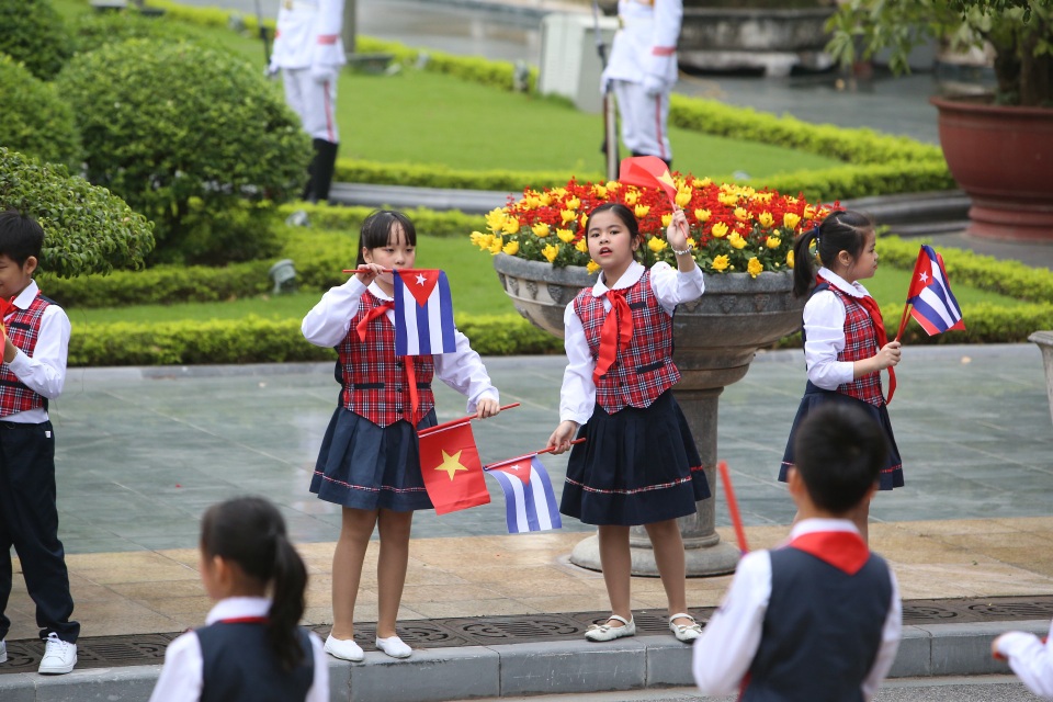Các cháu thiếu nhi Việt Nam cầm cờ chào đón lãnh đạo Cuba tới thăm