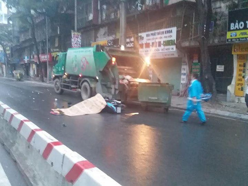 
Chiếc xe chở rác đỗ bên đường trong đêm mưa. (Ảnh: Lê Phương).
