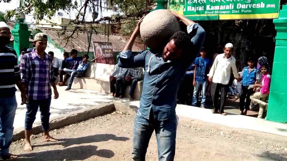 Một người bình thường thử sức nâng hòn đá lên vai