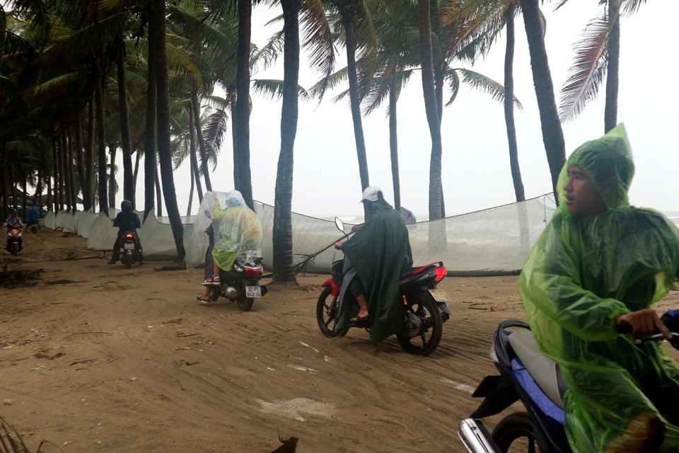 Người dân leo lề lên bờ biển Cửa Đại băng qua các nhà hàng để di chuyển vào trung tâm thành phố