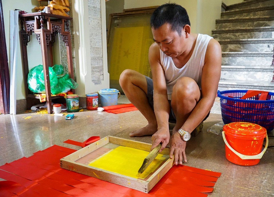 
Những tấm băng rôn sau khi lấy ra từ máy cắt sẽ được dập khuôn in chữ “Việt Nam vô địch”.
