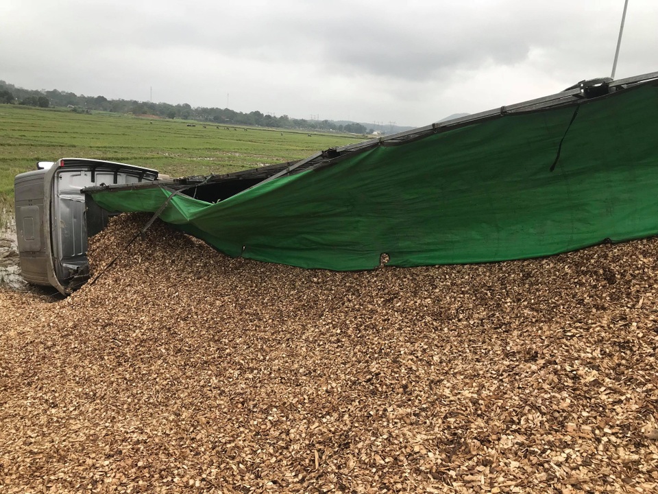 Chiếc xe chở gỗ dăm cũng lật xuống ruộng.