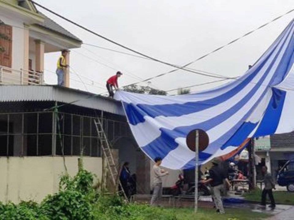 Dựng rạp, mổ lợn xem chung kết AFF cup tại nhà Văn Đức, Quang Hải - 2
Nhiều người đội mưa để căng bạt phục vụ xem trận chung kết.