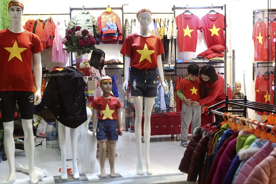 Hà Nội hừng hực khí thế cổ vũ đội tuyển Việt Nam - 7
Một bà mẹ đang thử cho con trai chiếc áo in cờ đỏ sao vàng để cổ vũ cho đội tuyển bóng đá Việt Nam.