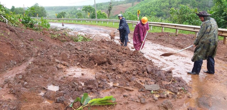 Cơ quan chức năng tiến hành dọn dẹp khu vực bị sạt lở gây cản trở giao thông (ảnh T.N)