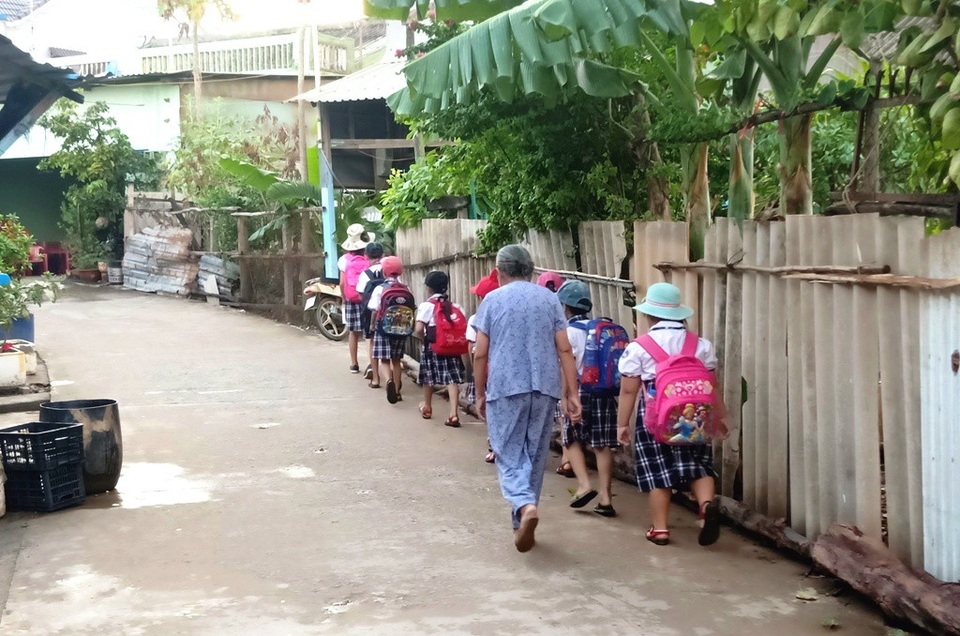 Cụ bà 81 tuổi gần 20 năm đưa đón học sinh từ nhà đến trường - 3 Dù ở tuổi 81, lưng đã còm nhưng bà Hai vẫn chưa thể bỏ nghề dẫn con nít đi học