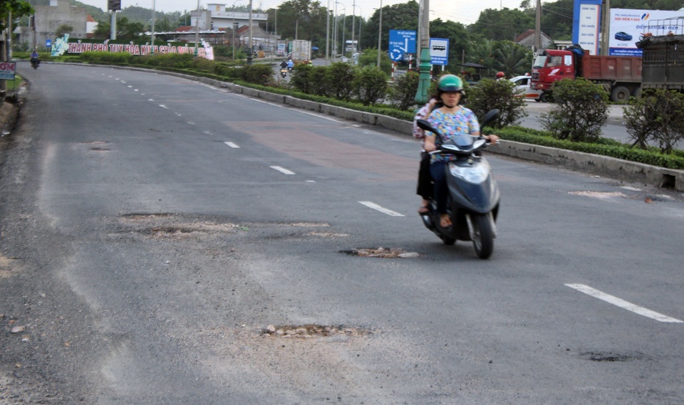 Vá “ổ gà” trên Quốc lộ 1 bằng đất đỏ và đá cục... ?! - 9 Một người lái xe máy vì né ổ gà mà tràn qua phần đường ô tô
