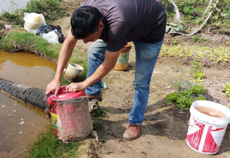 Những can, xô đầy dầu được người dân thu gom.