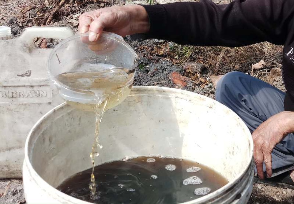 Những lớp dầu tràn được người dân thu gom.