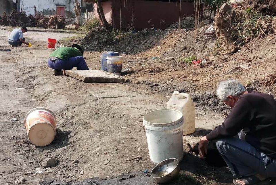 Nhiều người dân mang can, xô, chậu ra mương múc dầu tràn.