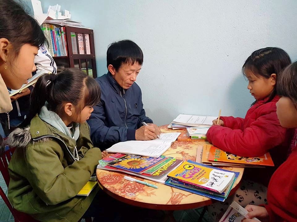 Thầy giáo làng say mê “truyền lửa” văn hóa đọc cho học sinh - 4 Thầy giáo làng Bùi Văn Đông hướng dẫn các em học sinh đọc sách.