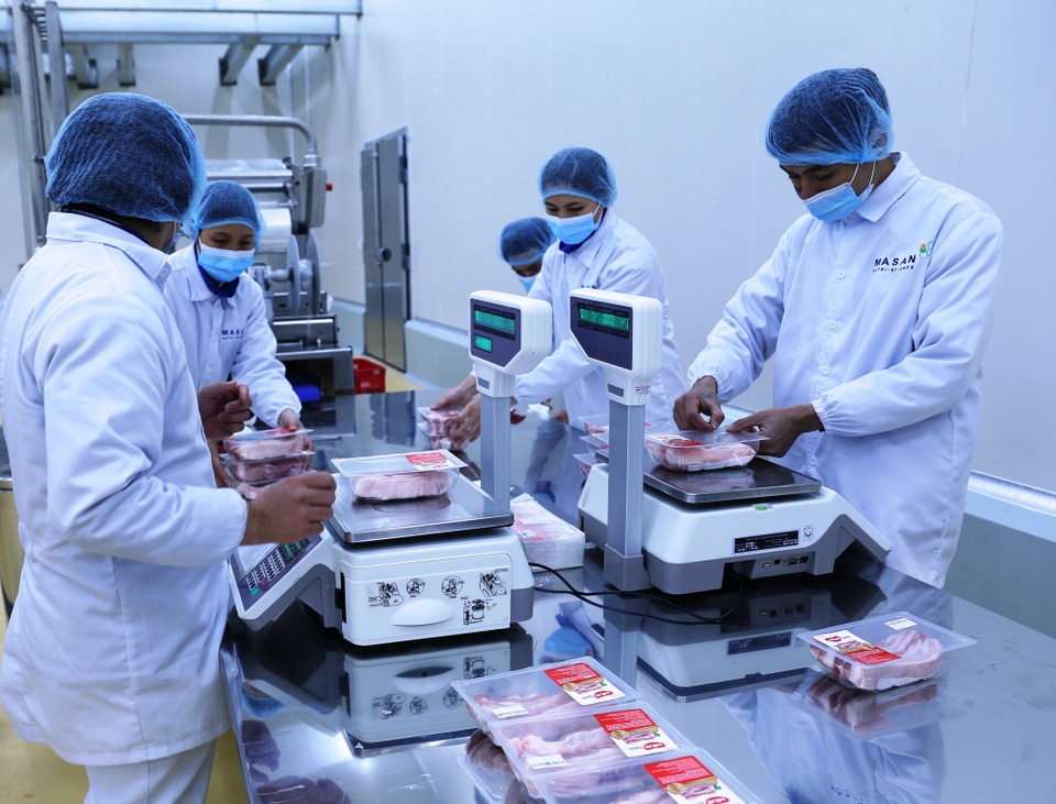 Đầu tư chế biến thịt - lối ra bền vững cho người chăn nuôi - 2 Nhân viên của Công ty Masan Meat Hà Nam đóng gói, cân và dán nhãn chứng nhận chất lượng sản phẩm.
