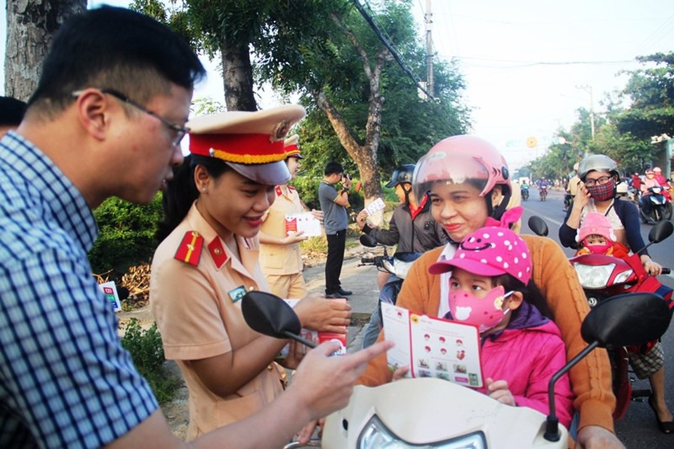 CSGT tặng phiếu mua mũ bảo hiểm cho phụ huynh “quên” đội mũ cho con - 2 CSGT tuyên truyền cho trẻ: Nếu lần sau bố mẹ chở đi học nếu không đội mũ thì con nhất quyết không ngồi lên xe đi học.
