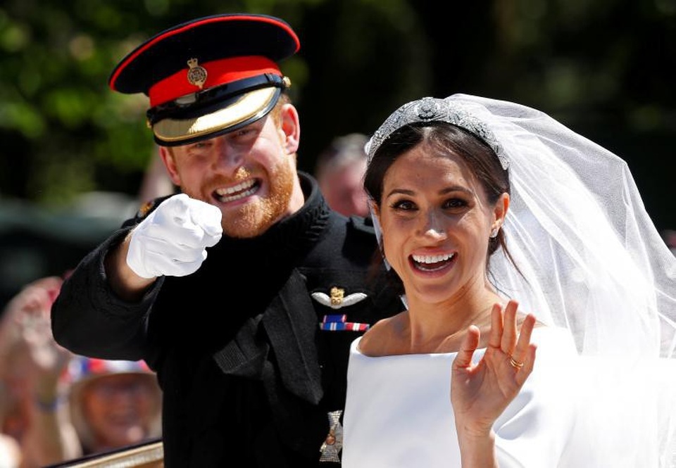 
Hoàng tử Anh Harry ngồi cạnh bạn gái Meghan trên xe ngựa trong lễ cưới hoàng gia tại cung điện Windsor ngày 19/5.
