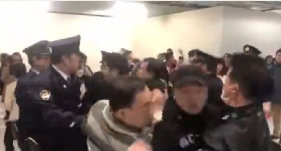 Những vụ bê bối nghiêm trọng liên quan tới khách du lịch Trung Quốc năm 2018 - 2 Nhóm khách Trung Quốc xô xát với cảnh sát Nhật Bản trong khi những người đứng sau hát quốc ca (Ảnh: Shanghaist)