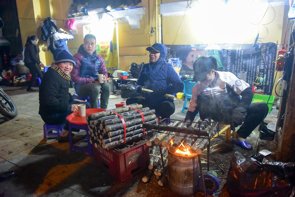 
Trời lạnh, những quán quà đặc thù như mía nướng, ngô nướng... đắt khách hơn ngày thường. Vừa ăn quà, khách còn tranh thủ sưởi ấm bên bếp lửa.
