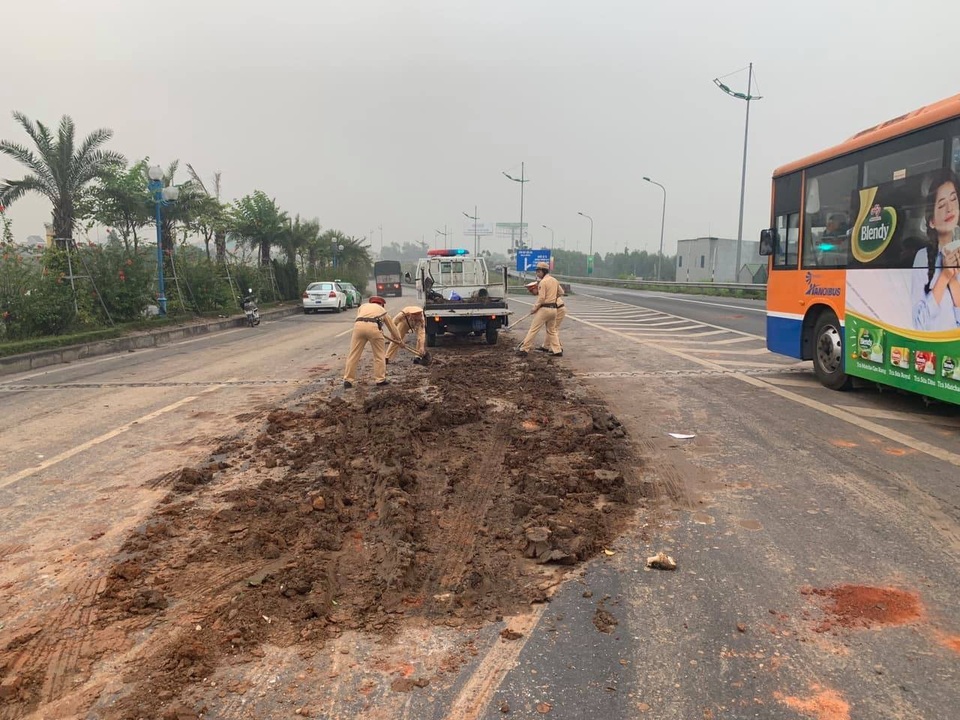 Hà Nội: Truy tìm xe rải bùn đất trên đường khiến 4 ô tô tông nhau - 2 Lực lượng CSGT đã tiến hành dọn dẹp bùn đất, đảm bảo an toàn cho các phương tiện di chuyển.