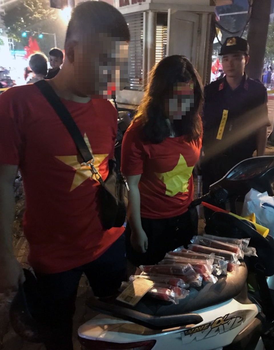Hà Nội: Đôi nam nữ mang pháo sáng đi cổ vũ bóng đá - 1 Đôi nam nữ mang pháo sáng đi cổ vũ bóng đá bị cảnh sát chặn dừng.