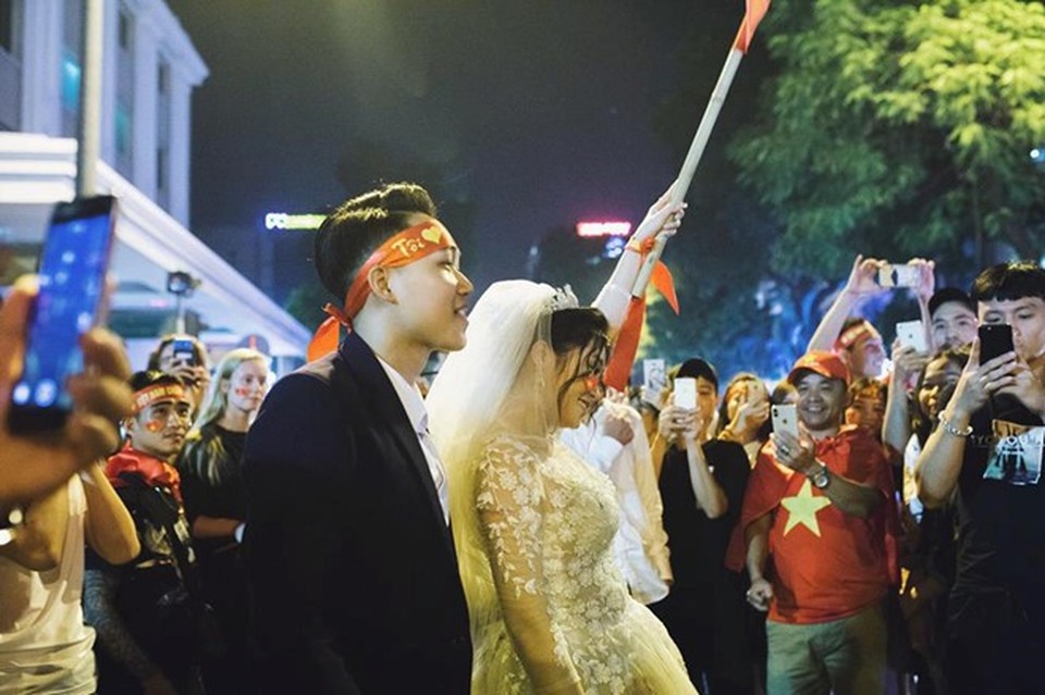 Cặp đôi “hoãn” chụp ảnh cưới, đi “bão” mừng chiến thắng của đội tuyển Việt Nam - 2 Khoảnh khắc cô dâu, chú rể nổi bật trong biển người ăn mừng chiến thắng. Ảnh: Hoàng Ken