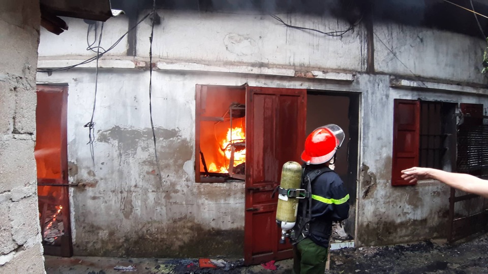 Kho hàng rộng 2.000m2 phục vụ Tết Nguyên đán bốc cháy ngùn ngụt - 6 Cảnh sát PCCC mang mặt nạ và bình dưỡng khí tiếp cận đám cháy.