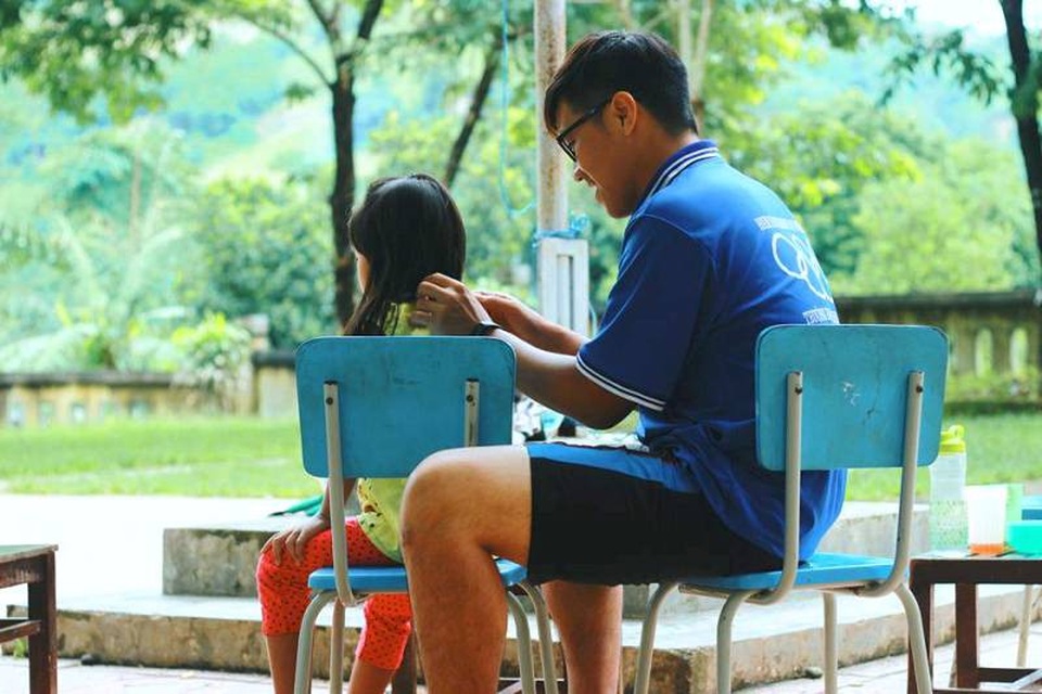Chàng sinh viên giỏi kiêm "thủ lĩnh" trong các phong trào tình nguyện - 1 Nguyễn Hữu Lập cắt tóc cho các em học sinh trong một chương trình tình nguyện.