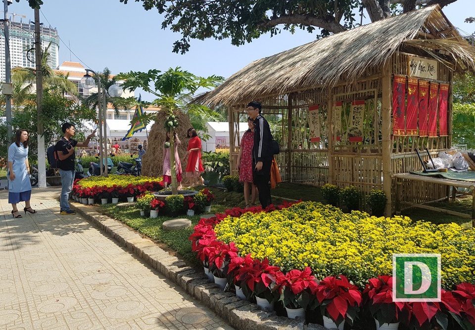 
Đôi nam nữ tạo dáng bên ngôi nhà lá theo kiểu Tết xưa
