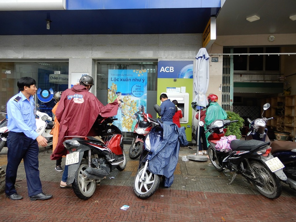 Xếp hàng dài trước cây ATM chờ rút tiền - 4 Tại một số điểm giao dịch, phải có sự can thiệp của nhân viên bảo vệ để đảm bảo an toàn cho khách hàng cũng như cây ATM