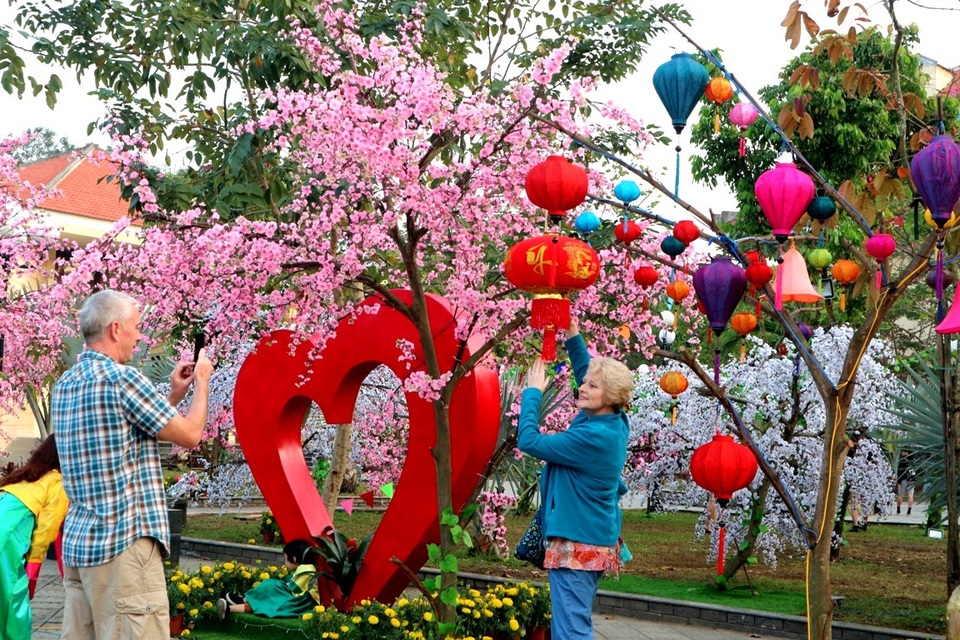 Du khách nước ngoài háo hức chụp ảnh kỷ niệm tại công viên Hội An với các mô hình Valentine và ngày Tết cổ truyền Việt Nam