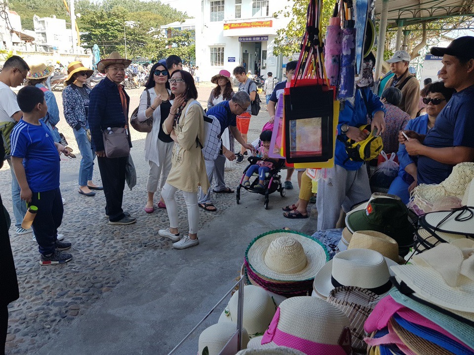 Nha Trang: Bến tàu du lịch đông nghịt khách ngày giáp Tết - 12 Du khách Trung Quốc bên một gian hàng bán mũ tại bến tàu Cầu Đá