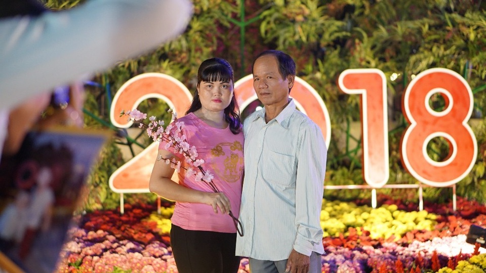 Đường hoa cho công nhân ở Nhà Bè vui Xuân - 12 Một cặp vợ chồng đang nhờ thợ chụp ảnh dịch vụ lưu lại kỉ niệm với đường hoa Mậu Tuất