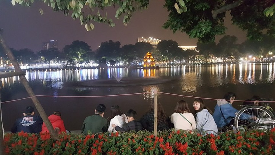 Pháo hoa bừng sáng, người dân cả nước nao nức mừng năm mới - 10
Nhiều người đã chọn chỗ và ngồi giữ chỗ bên bờ hồ để chờ xem pháo hoa