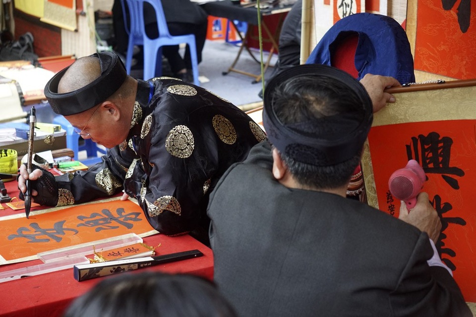 Hàng nghìn người tới Văn Miếu xin chữ đầu năm - 13
Ông đồ say sưa viết chữ, trong khi đồng nghiệp đang dùng máy sấy hong khô tác phẩm đã hoàn thành.