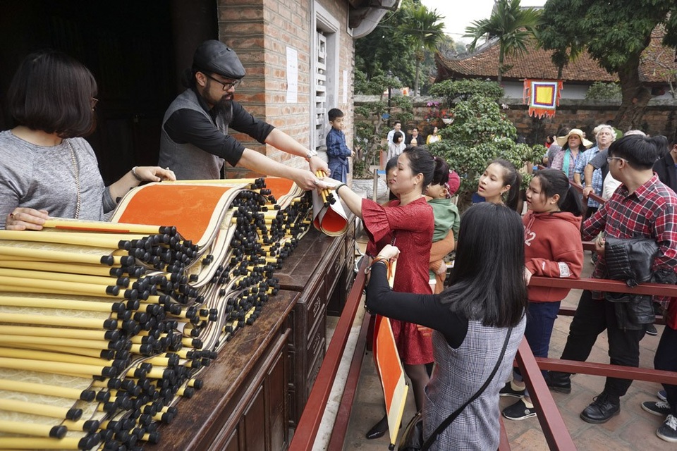 Hàng nghìn người tới Văn Miếu xin chữ đầu năm - 4
Người dân đủ mọi lứa tuổi phải xếp hàng mua giấy đỏ trước khi tới gặp các ông đồ xin chữ.
