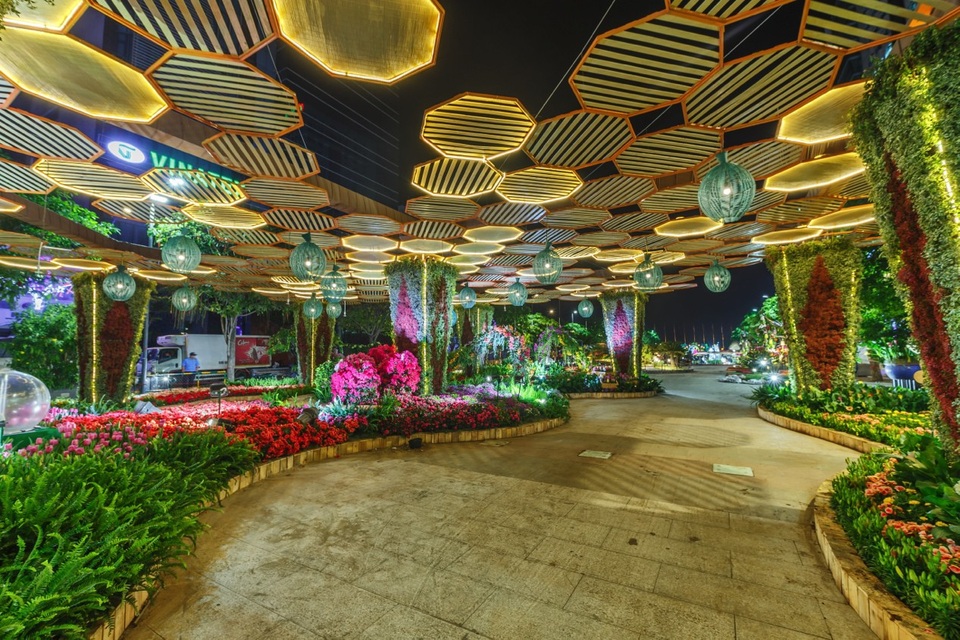 Một không gian độc đáo thu hút nhiều sự chú ý trên con đường hoa, với hệ thống mái mang tạo hình tổ ong tượng trưng cho tinh thần đoàn kết của dân tộc. Khi màn đêm buông xuống, những ánh đèn chiếu tạo nên một tổng thể không gian bắt mắt.