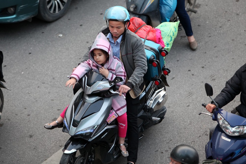 Hàng triệu người dân trở lại Thủ đô sau kỳ nghỉ Tết - 8
Hai cha con loay hoay giữa dòng phương tiện đông đúc trên phố Trần Quang Khải.