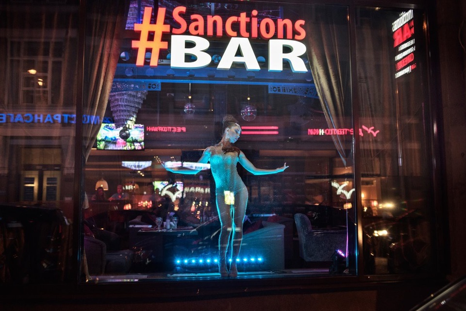 Những đứa trẻ lớn lên cùng Tổng thống Putin - 5 Một vũ công đứng sau cửa kính tại quán bar Sanctions (Trừng phạt) ở Moscow năm 2015. Quán bar này được thiết kế dựa trên ý tưởng về các lệnh trừng phạt của Mỹ và các đồng minh đối với Nga sau cuộc xung đột ở Ukraine.