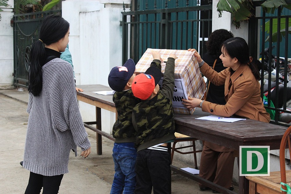 Các em nhỏ cùng mẹ đến đến bỏ tiền vào hòm công đức. Lễ phóng sinh làm việc thiện cũng là buổi lễ cầu an năm mới.