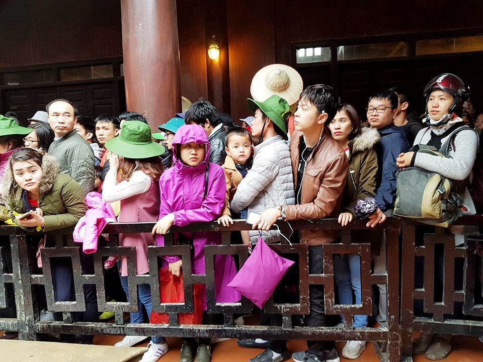 Ngộp thở chen lấn giữa “biển người” ở bến thuyền Tràng An - 5 Từng dòng người nối đuôi nhau đi theo hàng rào phân làn. Người trước nối tiếp người sau ngón chờ đợi lên phía trước. Vào dịp đầu năm mới, khu du lịch Tràng An luôn đông nghịt người vào các ngày cuối tuần. Đây là thời điểm người dân đến du xuân.