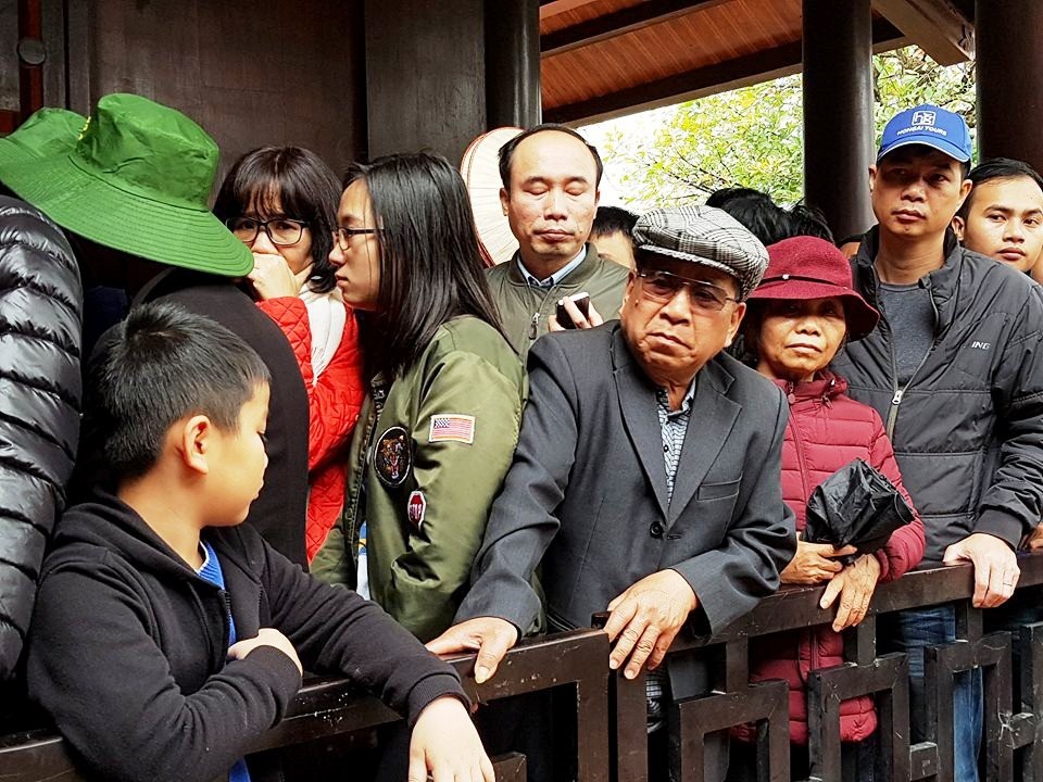 Ngộp thở chen lấn giữa “biển người” ở bến thuyền Tràng An - 10 Những người già không đứng được phía trong hàng phải chọn giải pháp đứng sát bên ngoài hàng rào để dễ chịu hơn. Do dòng người chen nhau xuống thuyền quá đông nên lực lượng an ninh có lúc đã phải đóng cửa đường vào để ổn định tình hình.