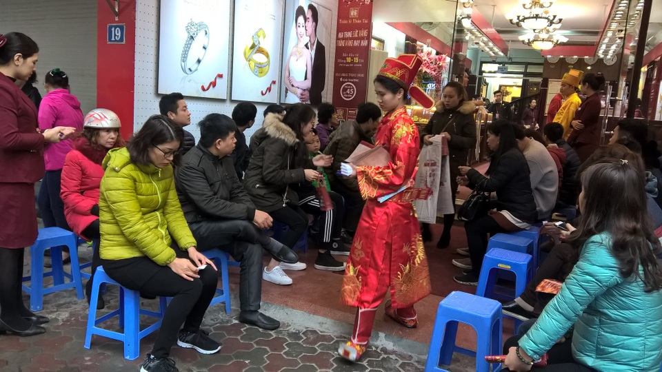 Ngày Vía Thần Tài: Cửa hàng đông đặc, nhà vàng trúng đậm - 4
Đến gần trưa, mưa ngày càng nặng hạt, người dân vẫn xếp hàng chờ đến lượt. Người người xếp ghế ngồi đợi đến lượt mua vàng tại Bảo Tín Minh Châu