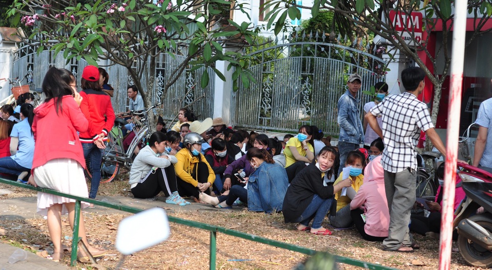 Vụ giám đốc người Hàn về nước: Hàng ngàn công nhân vạ vật chờ việc - 1 Các công nhân ngồi chờ đợi thông tin phía trước cổng doanh nghiệp