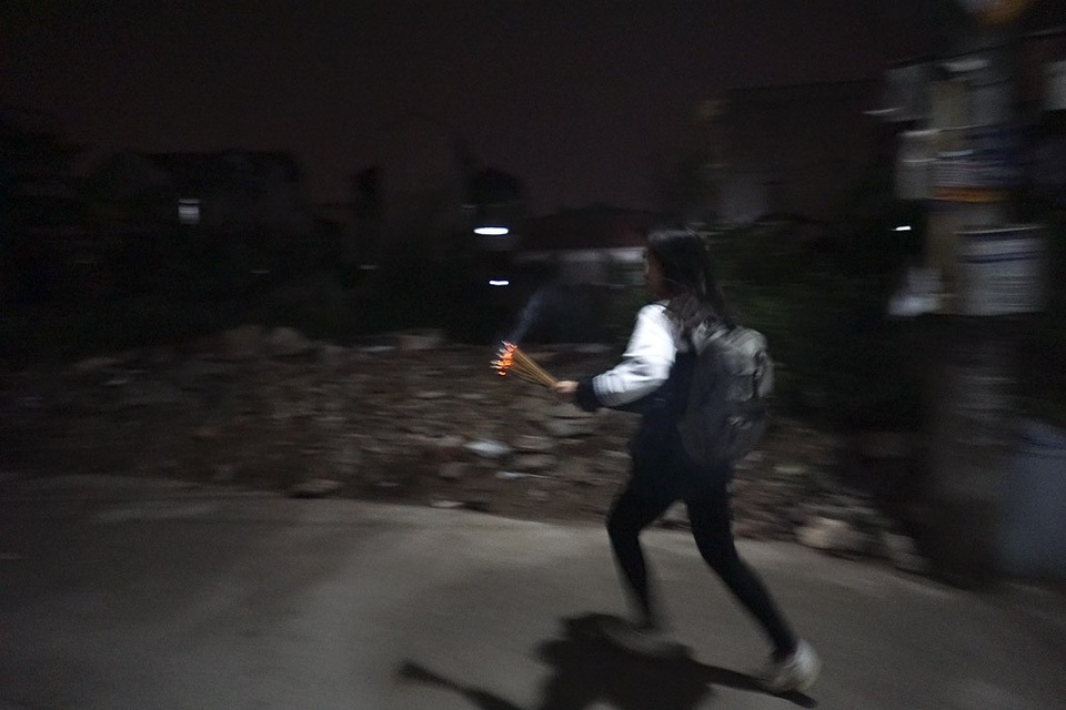 Hà Nội: Dân làng rước lửa về nhà trong đêm cầu may mắn - 14 Một học sinh đang lấy lửa mang về nhà.