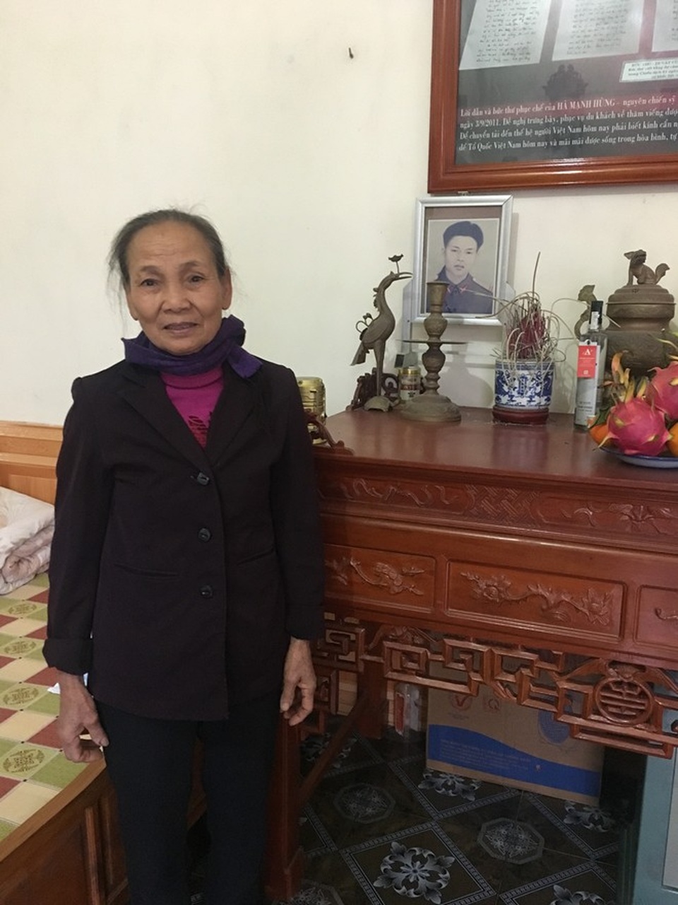 Bà Xơ bên ban thờ chồng.