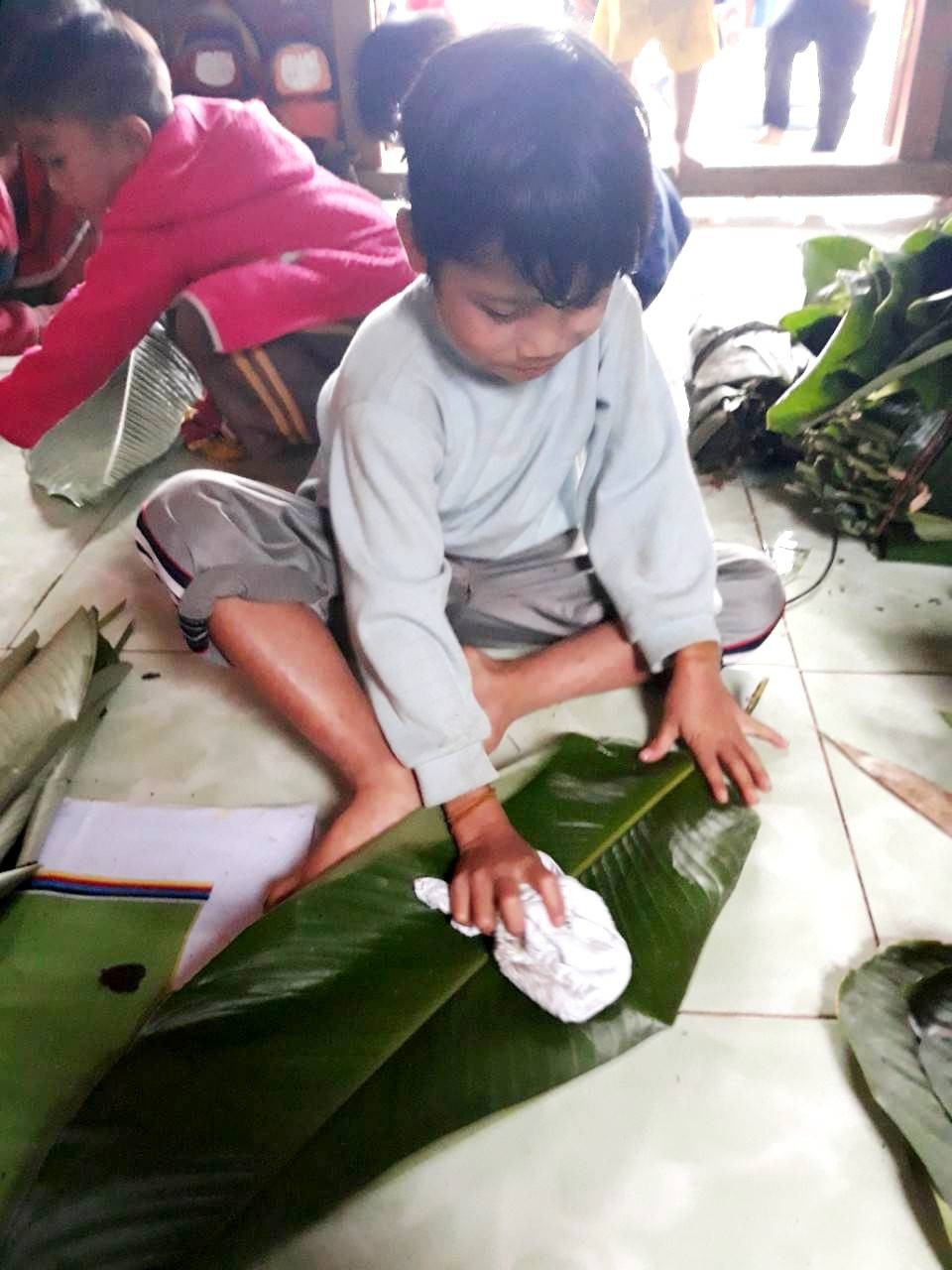 Cô giáo vùng cao dạy học sinh gói bánh chưng ăn Tết - 2
Các em tham gia lau lá để gói bánh.